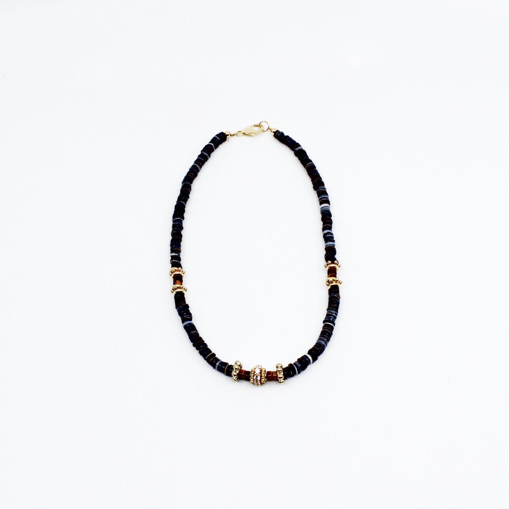 Stunning black puka mixed with gold plated spacers, gold platted spacers with cz detail, and brown beads. 16-18 inches in length. Handmade Jewelry. Stunning blue and gold necklace. Women Necklace. Girl Necklace. Gold Jewelry. Black Jewelry. Gold Jewelry. Brown Jewelry. Black Puka. Miami. Miami Jewelry. Affordable Sustainable Jewelry. Affordable Prices. Jewellery. Jewelry stores. Customized Jewelry. MCHARMS. Shop Jewelry. 