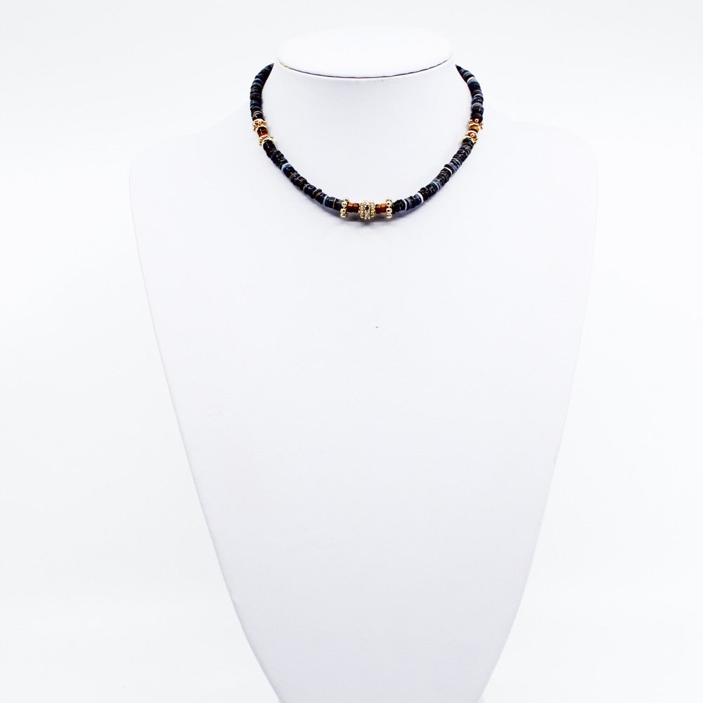 Black Tribal Puka. Stunning black puka mixed with gold plated spacers, gold plated spacers with cz detail, and brown beads. Handmade Jewelry. Stunning black and gold necklace. 16-18 inches in length. Shop Jewelry. MCHARMS. Women Necklace. Girl Necklace. Ocean Vibes. Gold Jewelry. Black Jewelry. Brown Jewelry. Miami. Miami Jewelry. Affordable Sustainable Jewelry. Affordable Prices. Jewellery. Jewelry stores. 