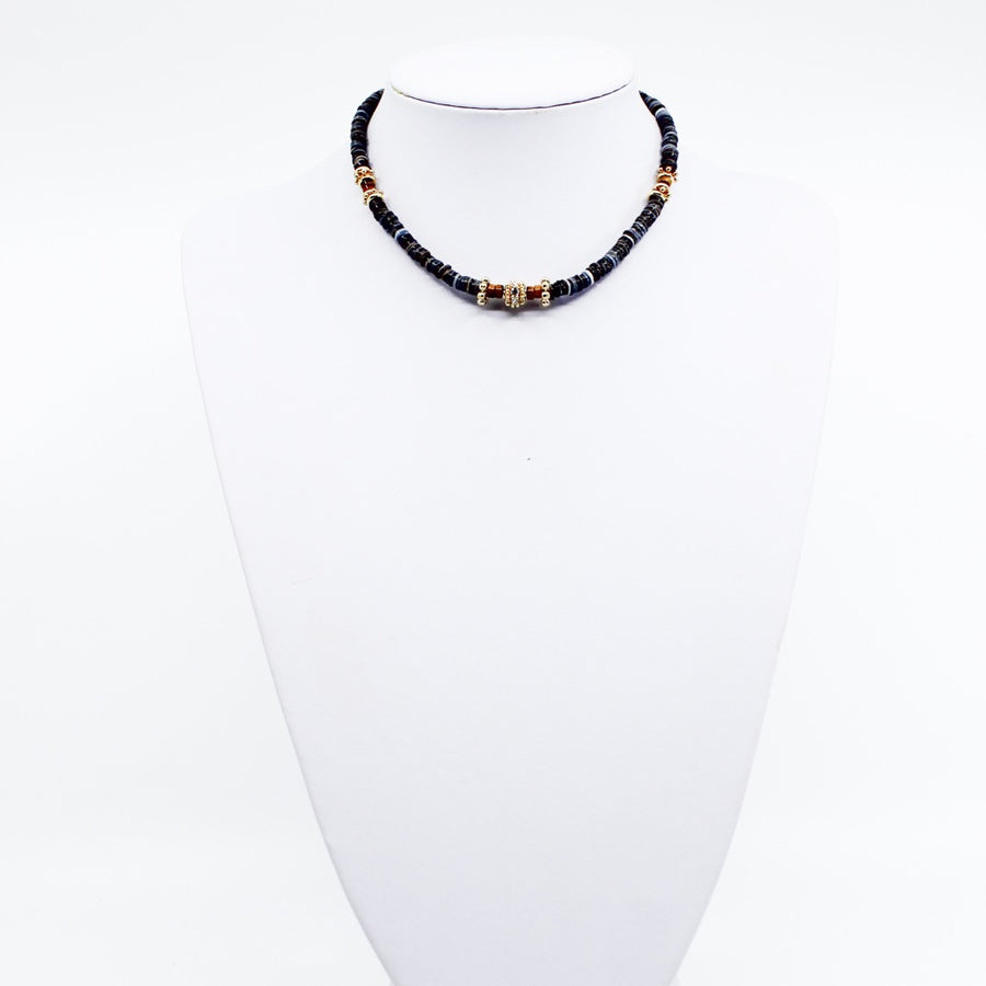 Black Tribal Puka. Stunning black puka mixed with gold plated spacers, gold plated spacers with cz detail, and brown beads. Handmade Jewelry. Stunning black and gold necklace. 16-18 inches in length. Shop Jewelry. MCHARMS. Women Necklace. Girl Necklace. Ocean Vibes. Gold Jewelry. Black Jewelry. Brown Jewelry. Miami. Miami Jewelry. Affordable Sustainable Jewelry. Affordable Prices. Jewellery. Jewelry stores. 